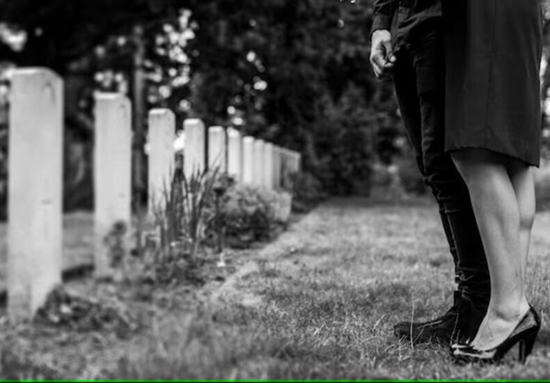 couple-standing-together-by-gravestone