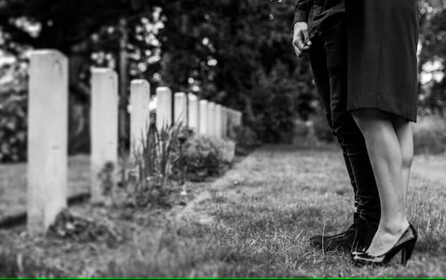 couple-standing-together-by-gravestone